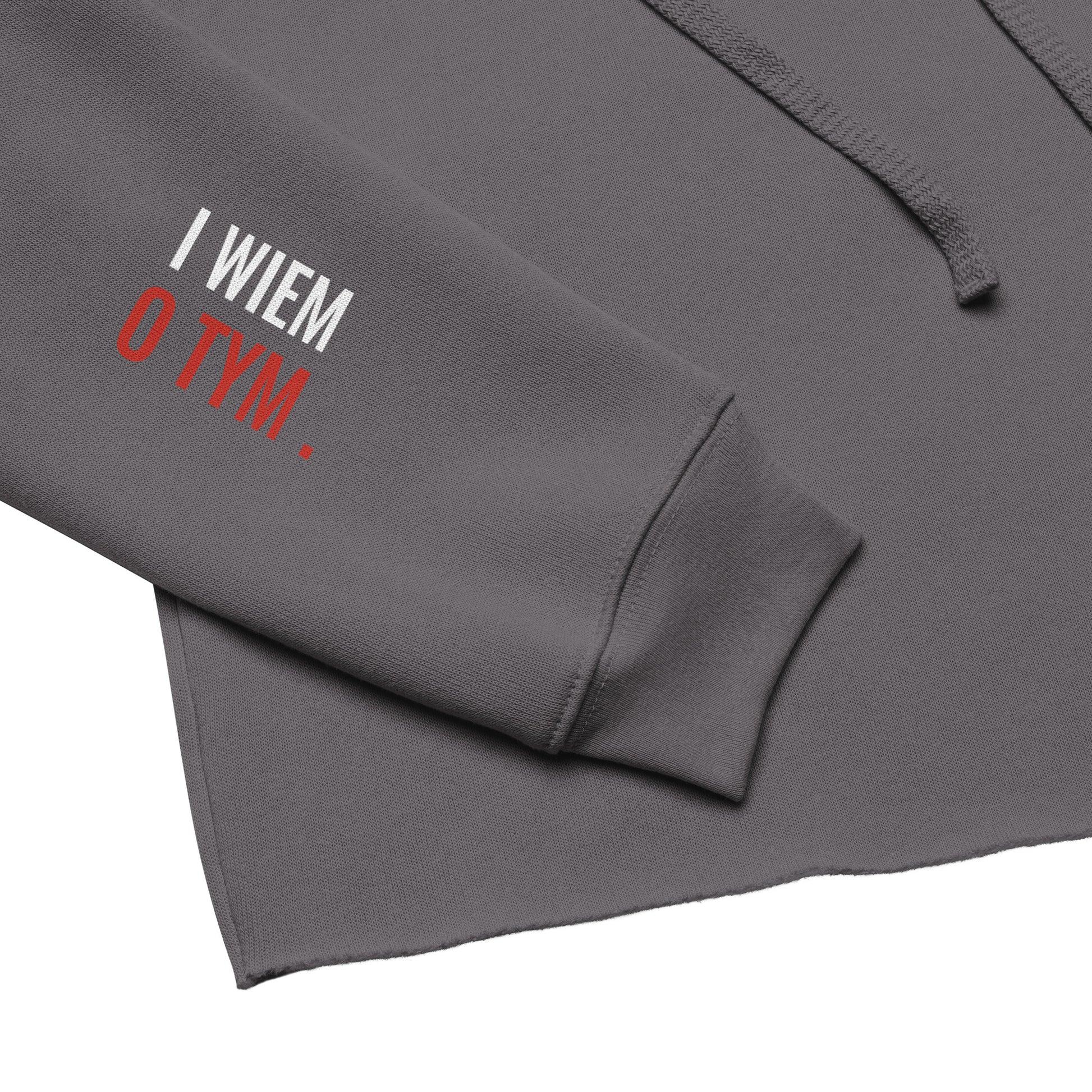 Detailaufnahme des rechten Ärmels des grauen Hoodies. Der Print zeigt den zweiten Teil der Botschaft: „i wiem o tym“.