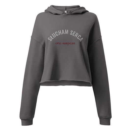 Frontansicht des grauen Cropped Hoodies von POLCOUTURE auf weißem Hintergrund. Auf der Vorderseite befindet sich eine hochwertige Stickerei: Der Schriftzug „słucham serca“ in Weiß und direkt darunter „ono szepcze“ in rot.