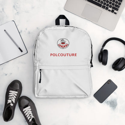 Der weiße Rucksack „PRZYGODA“ von POLCOUTURE in einer Flatlay-Ansicht, umgeben von Alltagsbegleitern wie Laptop, Notizbuch, Kopfhörern und Schuhen. Das Bild zeigt das geräumige Design und das Logo POLCOUTURE  im Kontext moderner Essentials.