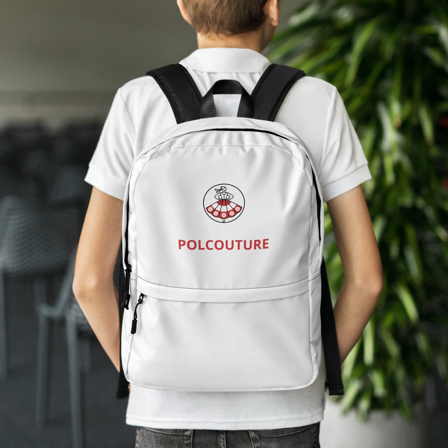 Ein Model von hinten mit dem weißen Rucksack „PRZYGODA“ auf beiden Schultern. Das POLCOUTURE All-Over-Muster steht im Fokus und zeigt die ideale Passform für tägliche Abenteuer.