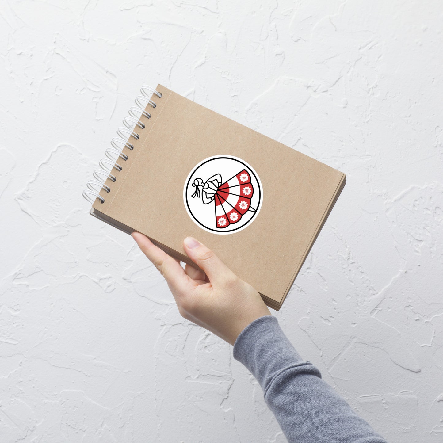 Die große Variante des weißen Logo-Stickers auf einem Notizbuch. Das markante POLCOUTURE Logo kommt hier besonders gut zur Geltung.