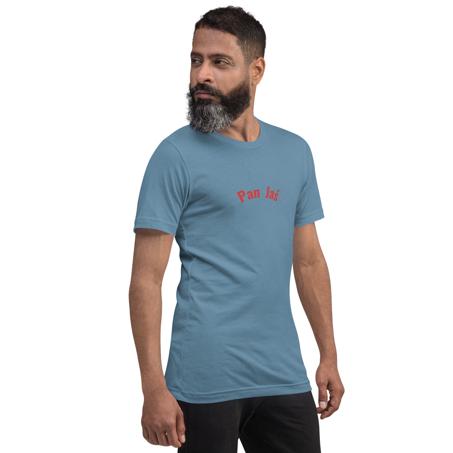 Ein Model trägt ein stahlblaues Unisex-T-Shirt von POLCOUTURE. Auf der Brust ist der Schriftzug „Pan Jaś“ im markanten POLCOUTURE Rot zu sehen. Das Model ist leicht nach rechts gedreht.