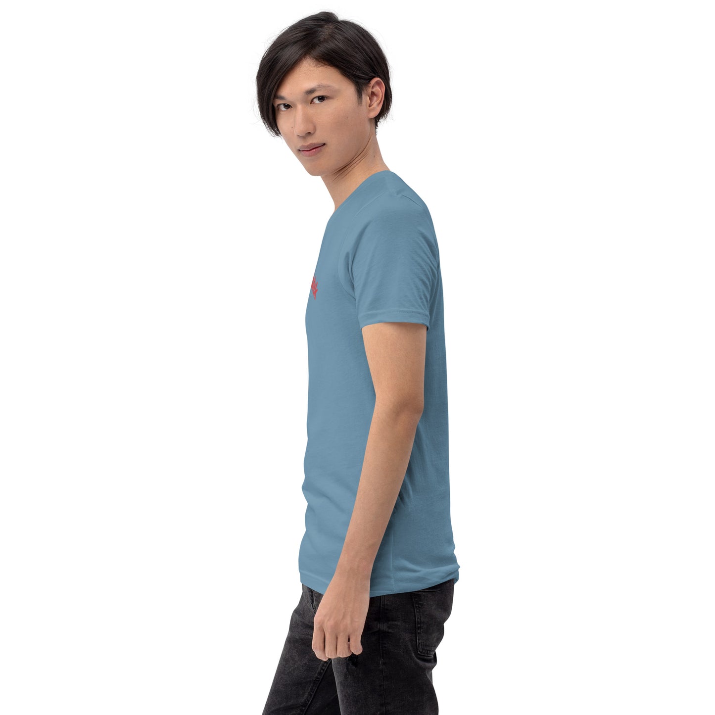 Seitenansicht eines Models in einem stahlblauen POLCOUTURE Unisex-T-Shirt. Auf der Brust ist der Name „Michałek“ in roter Schrift teilweise zu sehen. Die Ansicht betont den modernen Schnitt auf dem blauen Grund.