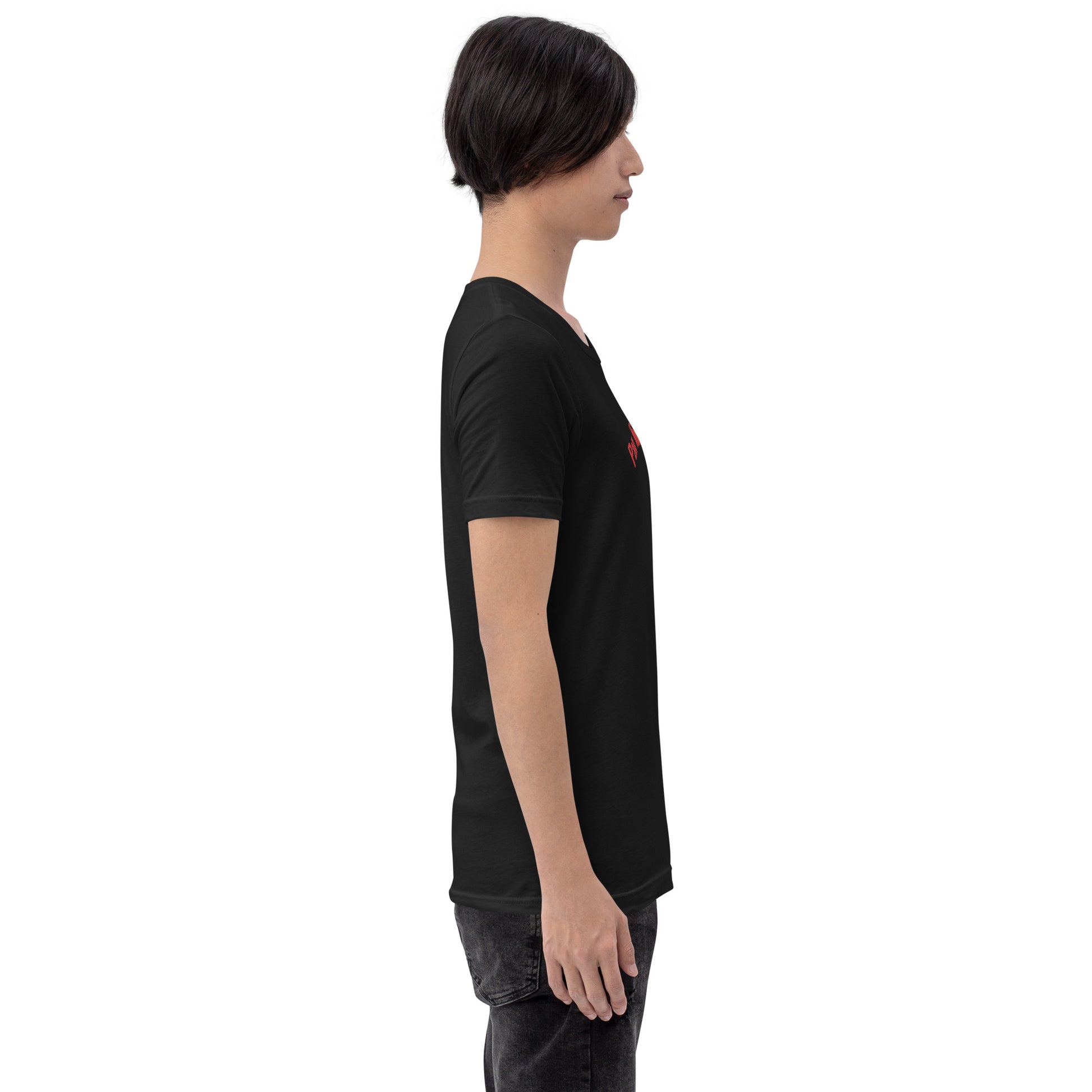 Seitenprofil eines Models in einem POLCOUTURE T-Shirt in Vintage Schwarz. Auf der Brust ist der Teil des Drucks „Pan“ in roter Schrift zu sehen. Die Ansicht betont den zeitlosen Look des dunklen Shirts.