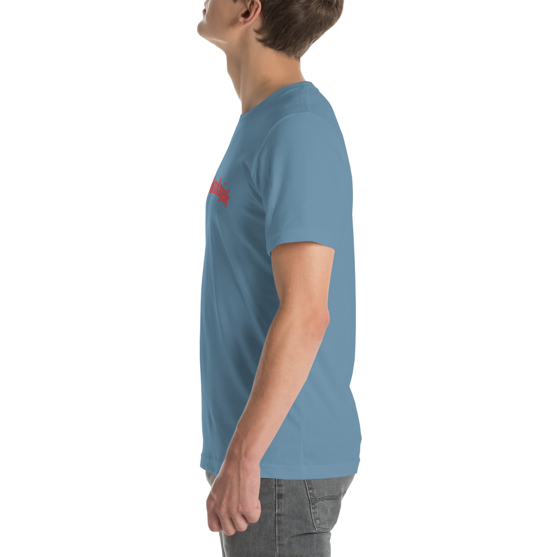 Seitenansicht eines Models in einem stahlblauen POLCOUTURE Unisex-T-Shirt. Auf der Brust ist der Name „Mikołajek“ in roter Schrift zu sehen. Die Ansicht betont den modernen Schnitt auf dem blauen Grund.