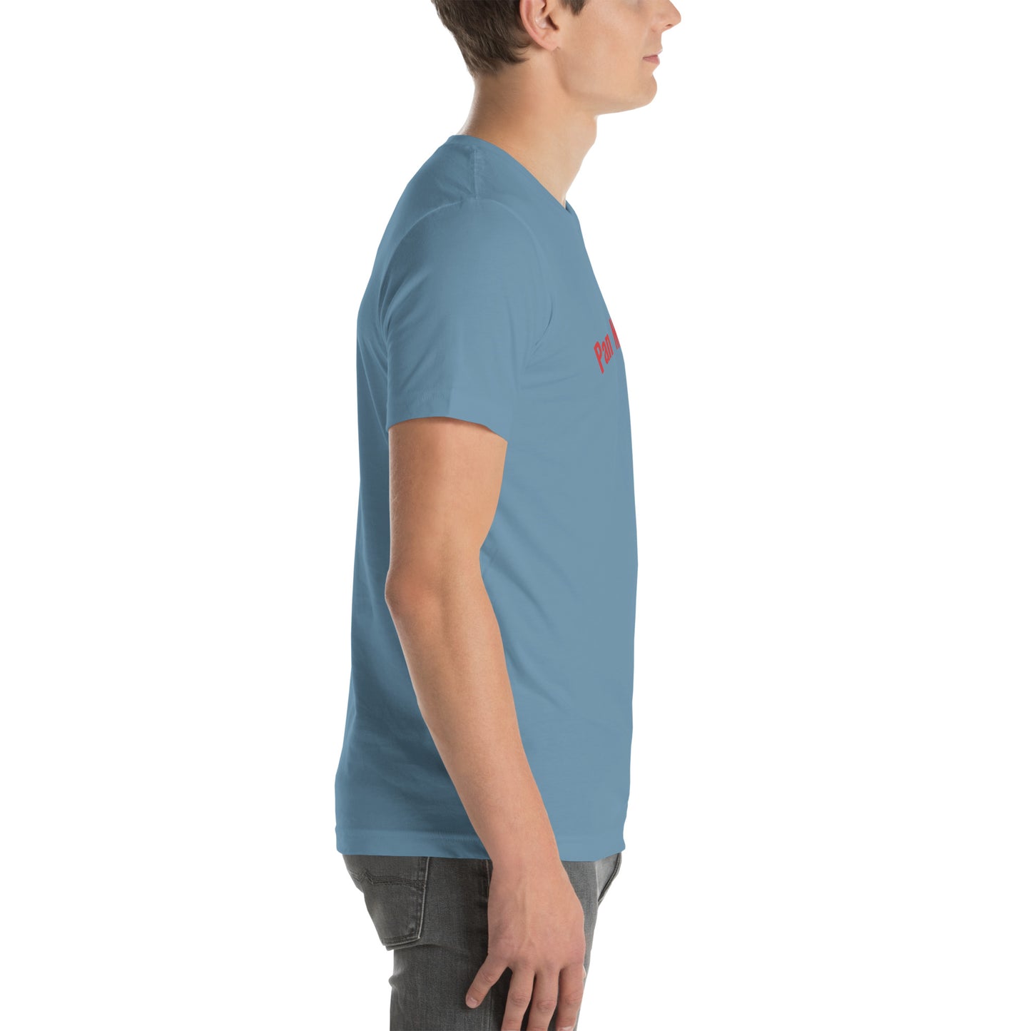 Seitenprofil eines Models in einem stahlblauen POLCOUTURE Unisex-T-Shirt. Auf der Brust ist der Teil des Drucks „Pan“ in roter Schrift zu sehen. Die Ansicht zeigt den hochwertigen Stoff in Steel Blue.