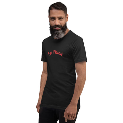 Ein Model trägt ein Unisex-T-Shirt in Vintage Schwarz von POLCOUTURE. Auf der Brust prangt der Schriftzug „Pan Piotruś“ im markanten POLCOUTURE Rot. Der dunkle Stoff bildet einen starken Kontrast zum Druck.