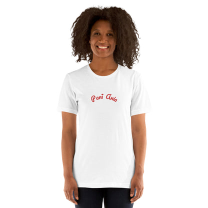 Ein Model trägt das weiße POLCOUTURE Unisex-T-Shirt mit dem verspielten roten Schriftzug „Pani Ania“. Das Design kombiniert den lockeren Schnitt mit dem feinen Herz-Detail.