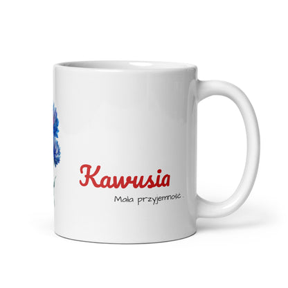 Weiße Keramiktasse „KAWUSIA“ von POLCOUTURE auf weißem Hintergrund. Der Henkel zeigt nach rechts; im unteren Bereich sind der Schriftzug „KAWUSIA“ und der Slogan „Moja przyjemność“ platziert.