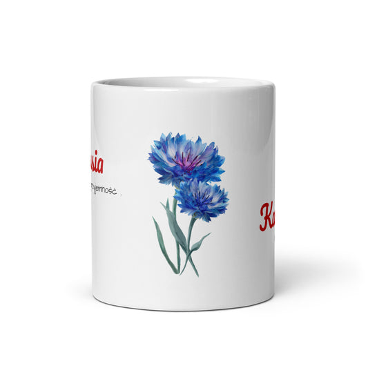 Frontalansicht der weißen Tasse „KAWUSIA“ vor weißem Hintergrund. Man sieht deutlich das florale Design mit leuchtend blauen Kornblumen, die dem POLCOUTURE Becher einen frischen, sommerlichen Look verleihen.