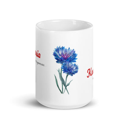 Frontalansicht der weißen POLCOUTURE Tasse. Das Design zeigt eine minimalistische Illustration von zwei Kornblumen.