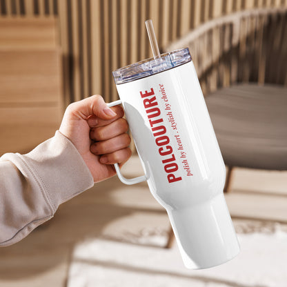 Der weiße Travel Mug „ŁYK“ in der linken Hand präsentiert das POLCOUTURE Logo und den Slogan „polish by heart . stylish by nature“ in der markanten Architects Daughter Schrift.